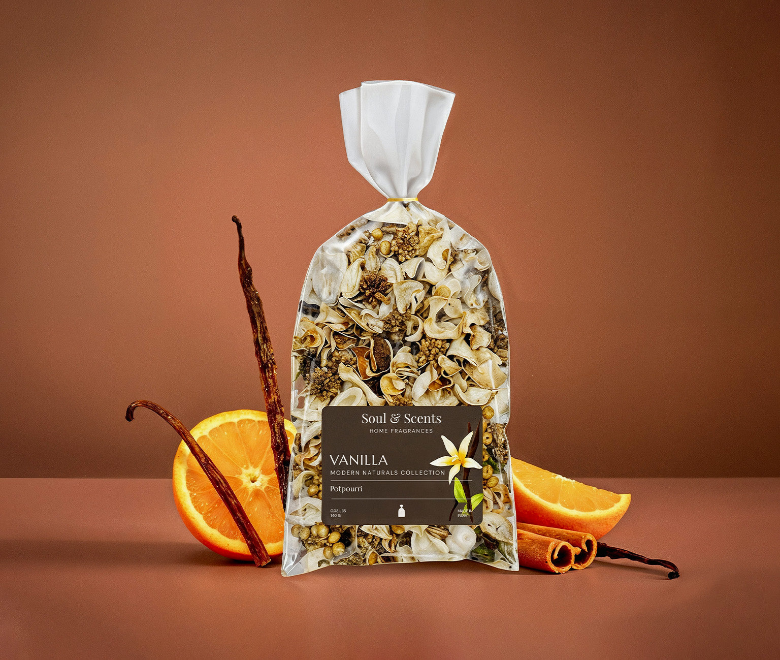 Bag of vanilla-scented potpourri with vanilla beans and oranges on a brown background