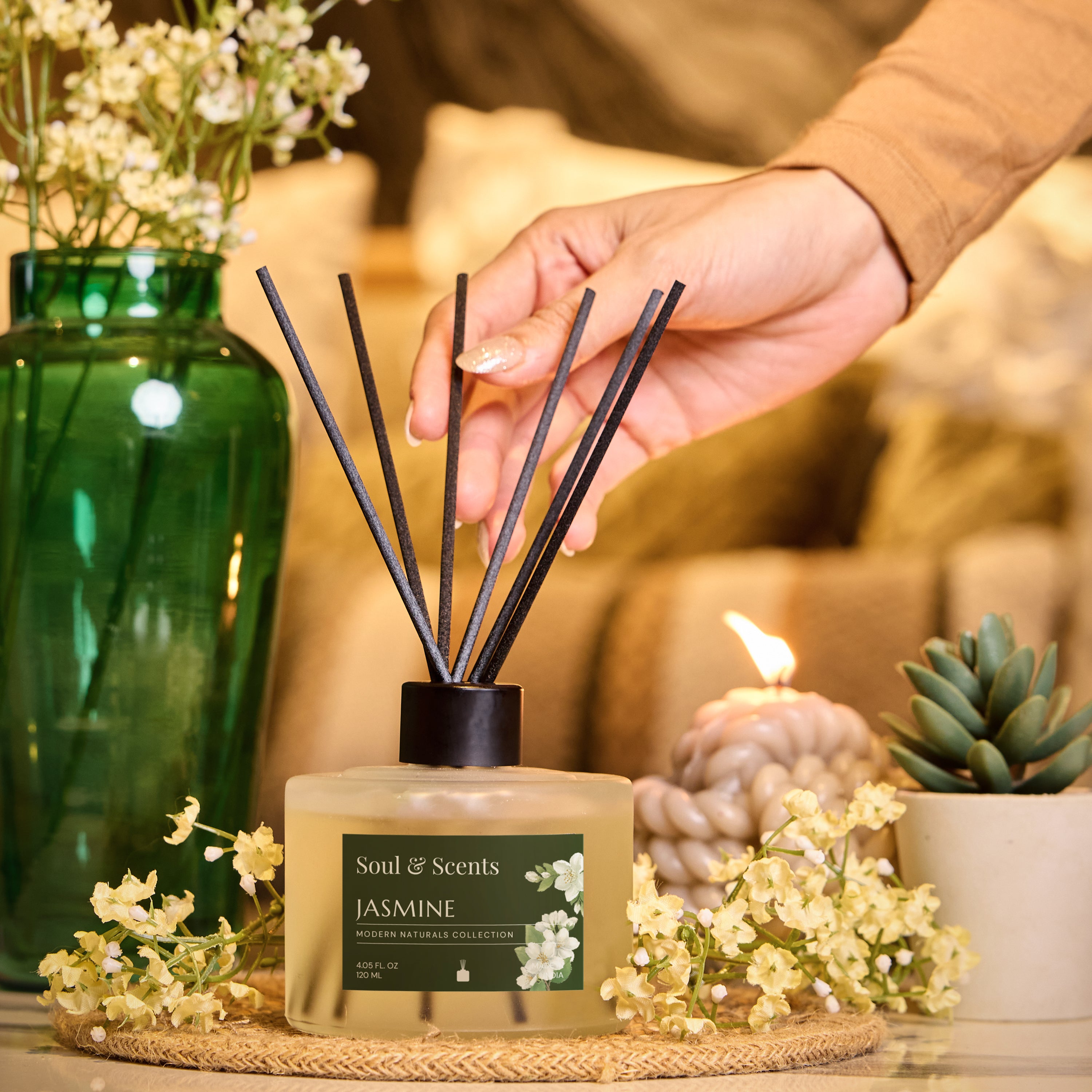 Scented diffuser labeled 'Soul & Scents Jasmine' on a table with decorative elements.