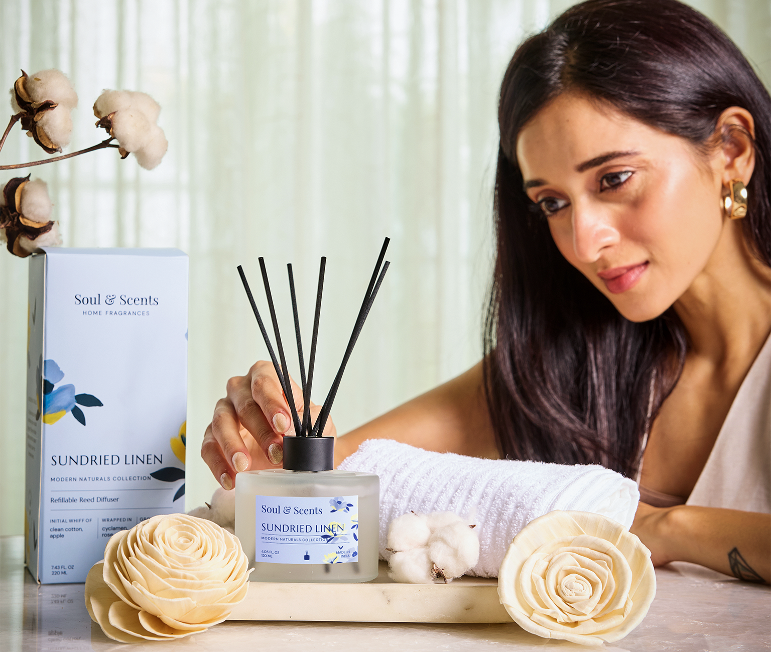 Woman using a diffuser with 'Soul & Scents' product on a table