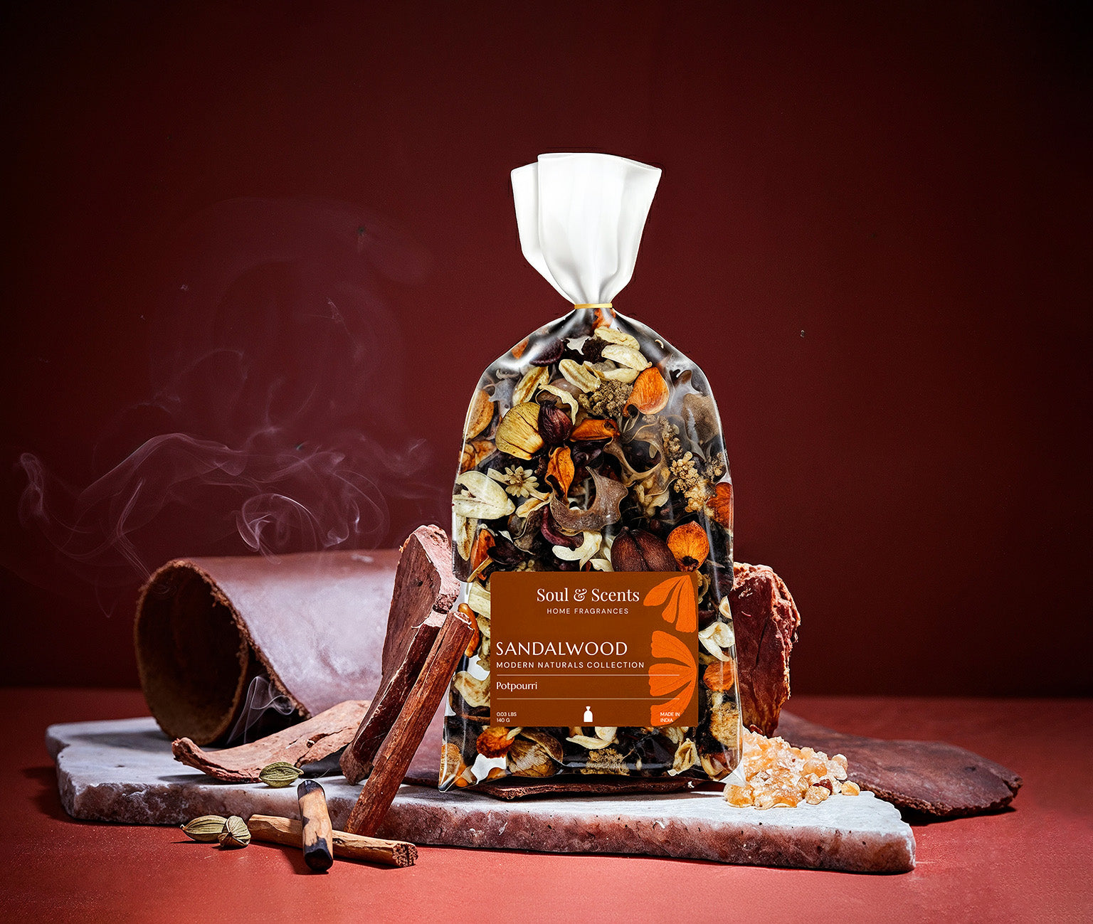 Sandalwood incense packaging with incense sticks and materials on a red background