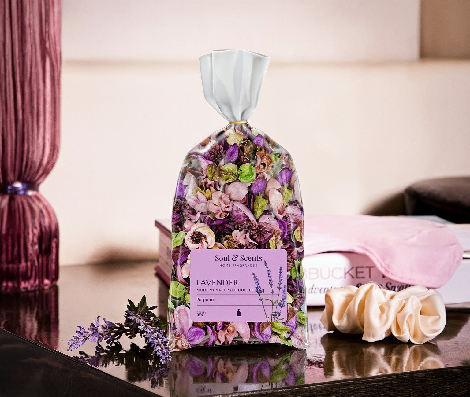 Scented bag with floral design and lavender packaging on a reflective surface.